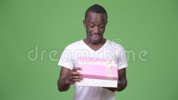 年轻快乐的非洲男人打开礼品盒时显得很惊讶视频的预览图