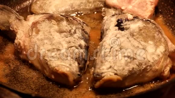 以面粉为面包的鱼头用油在煎锅里煎视频的预览图