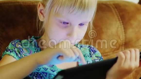 疲惫的女孩在平板电脑上玩游戏傍晚视频的预览图