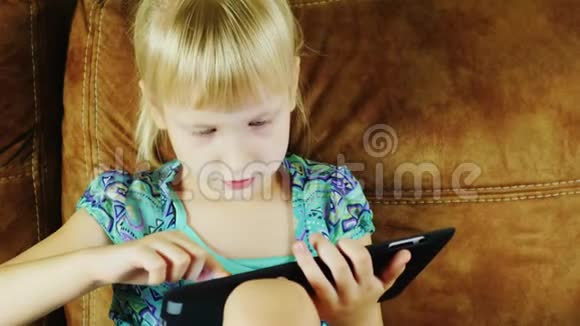 金发女孩深夜在平板电脑上玩视频的预览图