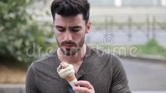 年轻人站着吃着美味的冰淇淋视频的预览图