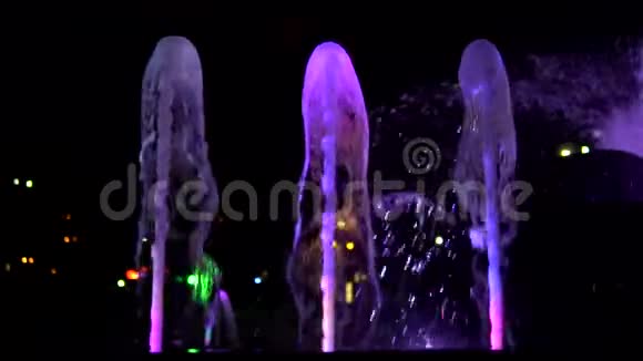 紫罗兰色的水流在喷泉的夜间超级缓慢的运动视频的预览图
