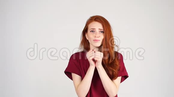漂亮的红发女孩乞求说请在白色背景上祈祷视频的预览图