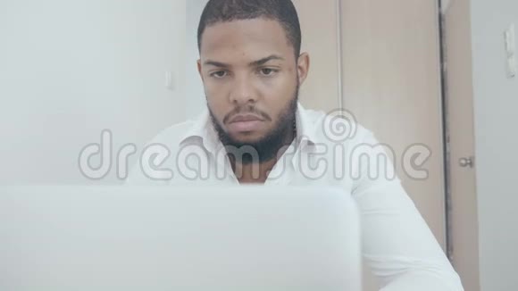 严肃的黑人工作使用电脑在办公室里看监控屏幕非裔美国商人视频的预览图