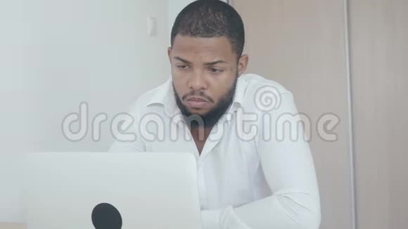 严肃的黑人工作使用电脑在办公室里看监控屏幕非裔美国商人视频的预览图