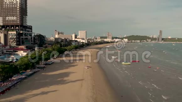 芭堤雅海滩的4k无人机空中飞行和著名标志清晨日出的城市景观和天际线展现金色沙滩视频的预览图