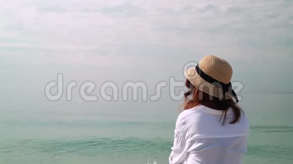 戴帽子的女人看海的后景视频的预览图