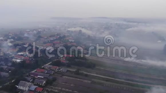 村内正在冒烟大气污染烧毁田间杂草秋天乌克兰无人驾驶飞机的空中景观视频的预览图