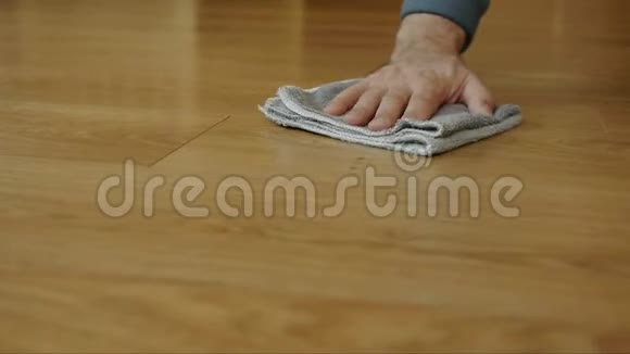 一个人用一特殊的布擦拭木地板上的污垢视频的预览图
