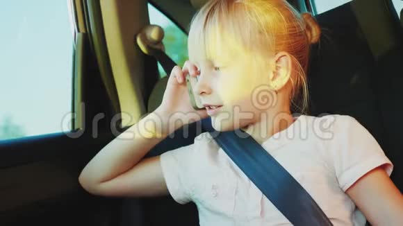 在车里旅行女孩在打电话坐在后座视频的预览图