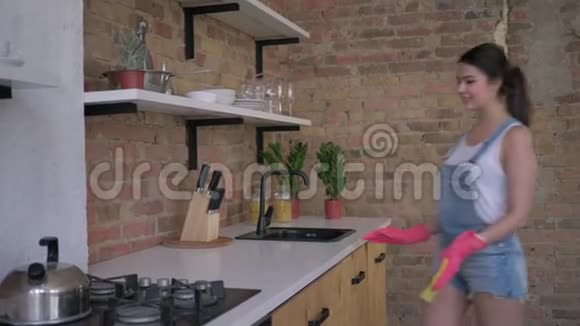 家务活快乐的女家庭主妇戴着橡胶手套清洁脏家具视频的预览图