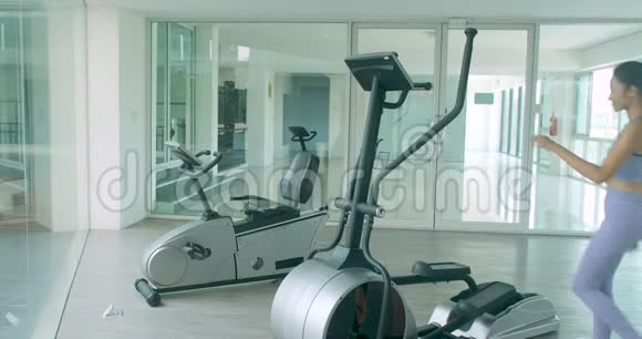 亚洲女孩在健身房的椭圆机上锻炼心脏视频的预览图