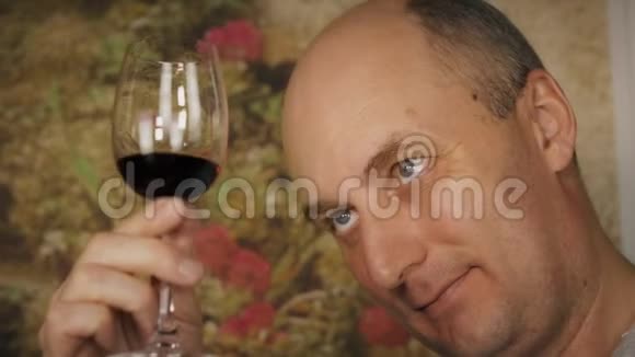 面人在品尝前看着酒杯里的红酒喝红酒的男人视频的预览图