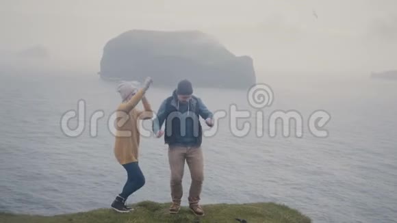 年轻时尚的夫妇在一起玩得很开心雾天男人和女人在海边跳舞视频的预览图