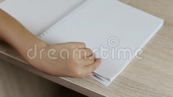 女孩手拇指穿过笔记本的页面用空纸张关闭规则纸笔记本服务台视频的预览图