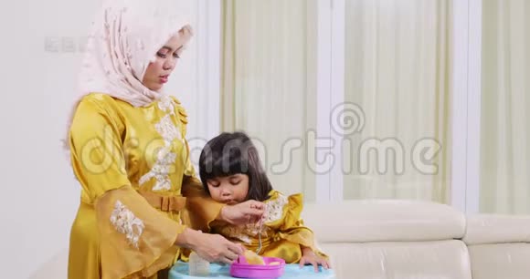 年轻的穆斯林妇女喂养她的女儿视频的预览图
