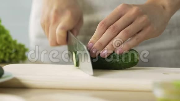 女士切鲜黄瓜做健康沙拉家庭晚餐特写视频的预览图