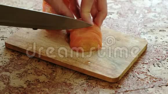 特写男在厨房桌子上的木板上切西红柿视频的预览图