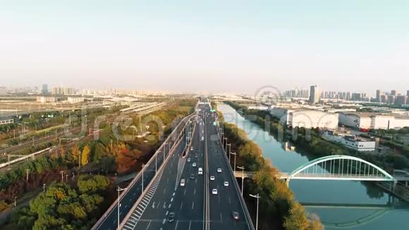 日落时用汽车和卡车俯瞰高速公路和立交桥大都市中一个现代化的天桥路口视频的预览图