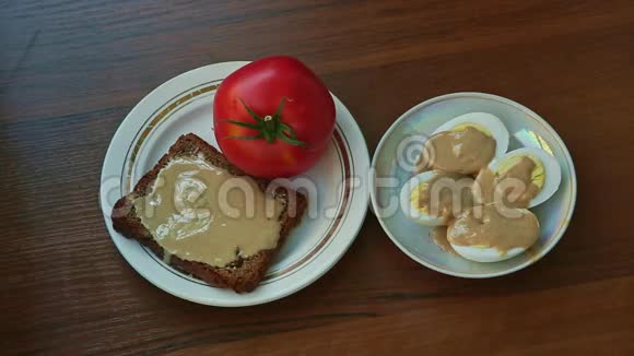 手拿盘子和煮熟的鸡蛋盘子和番茄和黑麦面包视频的预览图