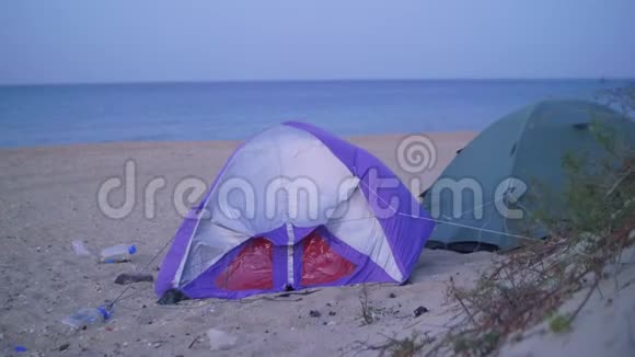 海滩上的几顶帐篷背景是模糊的海洋视频的预览图