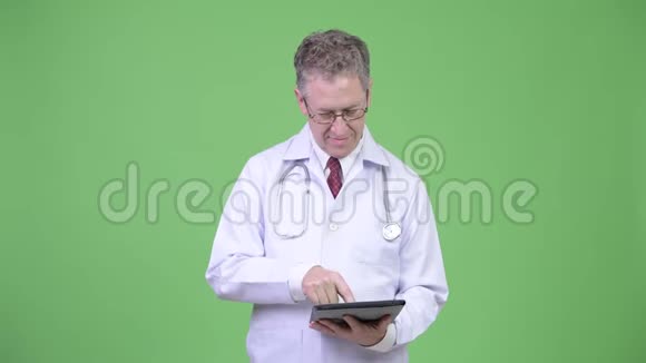 幸福成熟男医生使用数码平板电脑的画像视频的预览图