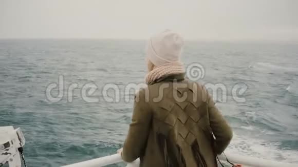 在船上年轻的金发女子站在船上怅惘地看着大海探索冰岛视频的预览图