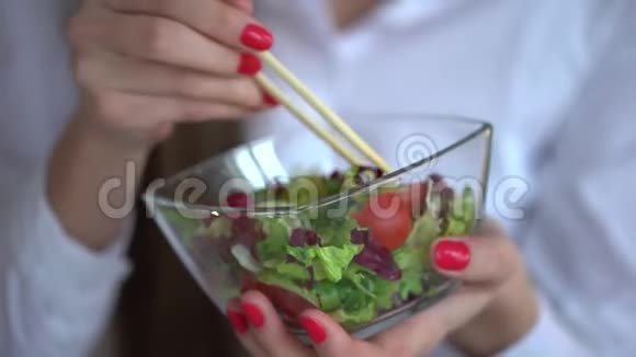 优雅的女商人在她的工作场所吃午饭的4K视频在办公室吃蔬菜沙拉的女人4k视频的预览图