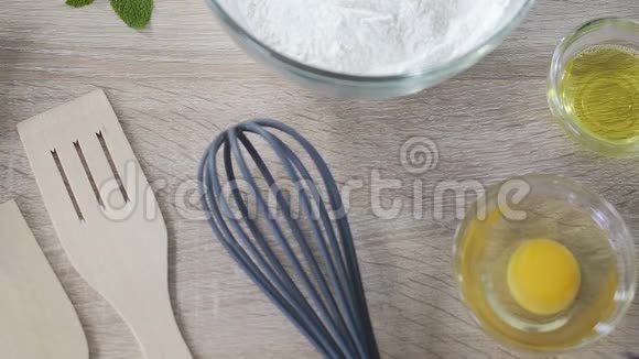 女士在面粉中加入鸡蛋用木勺混合配料蛋糕配方视频的预览图