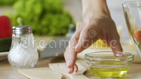 女士在新鲜沙拉中加入橄榄油并在碗中搅拌健康饮食视频的预览图