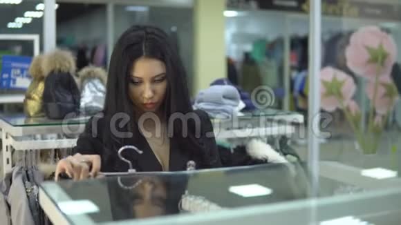 年轻女子在商场或服装店看价格标签视频的预览图