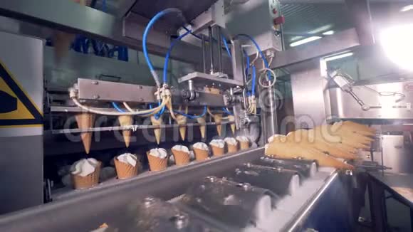 空的晶片锥被放入工厂机器而装满奶油的锥被从一台机器上移开视频的预览图