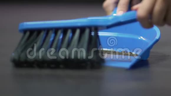 用刷子将垃圾从地板上从铲子上扫下来清洁女性的双手视频的预览图