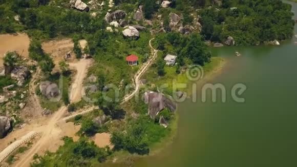 空中景观山路上背景绿湖和大石头沿着湖岸和绿岩山景的道路视频的预览图