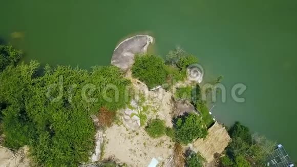 大石于绿水山湖鸟瞰飞行无人机飞越岩石海岸山湖视频的预览图