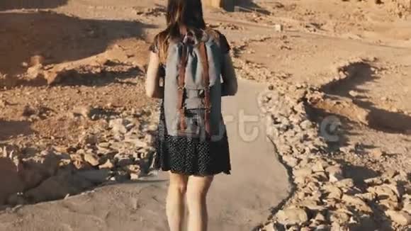 带背包的女人探索古老的沙漠废墟美丽的欧洲游客走在岩石和沙子上马萨达以色列4K视频的预览图