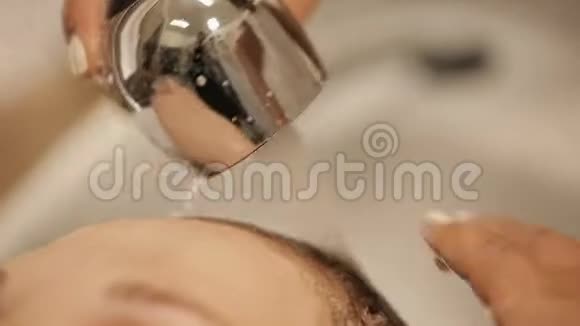 美容师为客户洗头并在美容美发店使用化妆霜视频的预览图