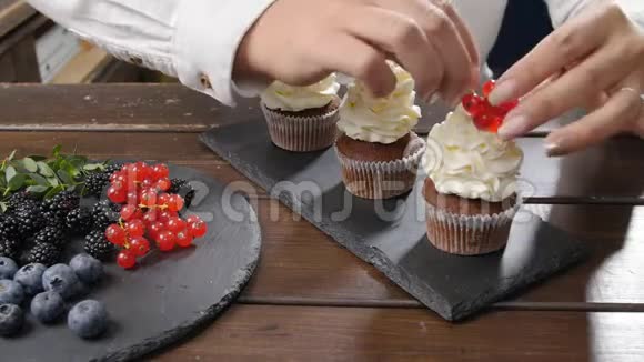 小企业和糖果的概念女面包师装饰美味的纸杯蛋糕视频的预览图