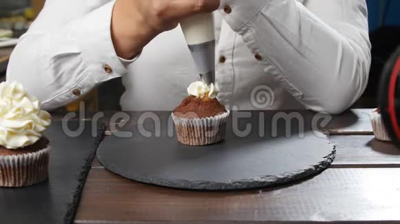 小企业和糖果的概念女面包师装饰美味的纸杯蛋糕视频的预览图