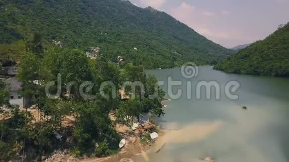 美丽的山河和岸上建筑鸟瞰图路在青山无人机拍摄绿化景观视频的预览图
