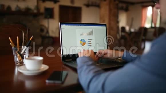 在咖啡馆里自由职业者商人在眼镜上辛勤工作人在电脑键盘上打字视频的预览图