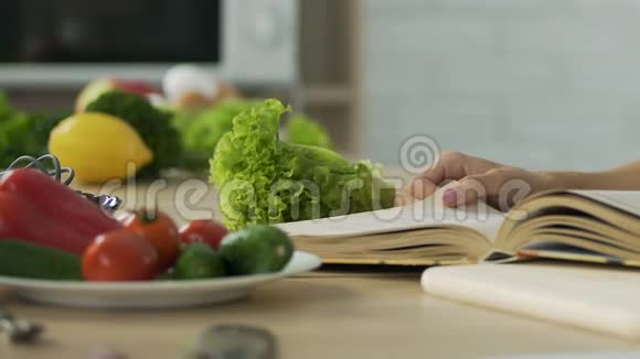 女人在家看老奶奶的食谱书精致的晚餐配料视频的预览图