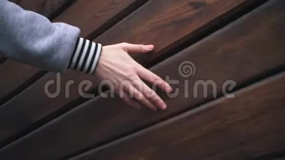 女性手触摸一堵木墙视频的预览图