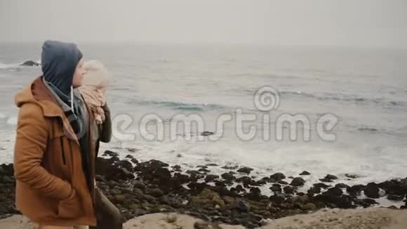年轻夫妇一起在海边散步在水边的浪漫约会中旅行男女视频的预览图