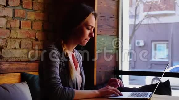 女学生在咖啡馆用笔记本电脑打字视频的预览图