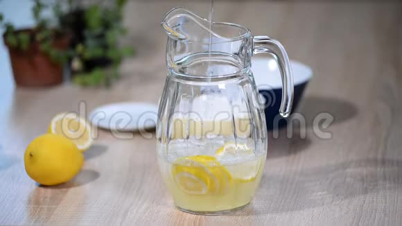 在一壶柠檬里倒水一杯苏打水喝柠檬水加冰和白柠檬片视频的预览图