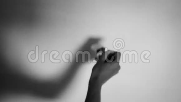 女性用画笔将墙壁涂成白色黑白拍摄16mm风格的特写镜头视频的预览图