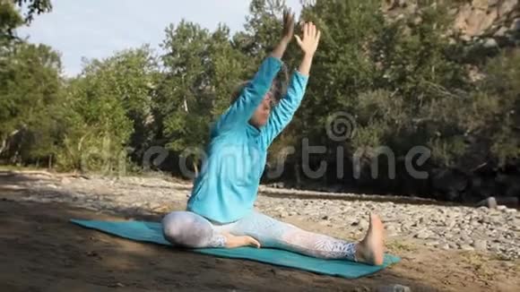 在大自然中一个年轻女孩在做瑜伽视频的预览图
