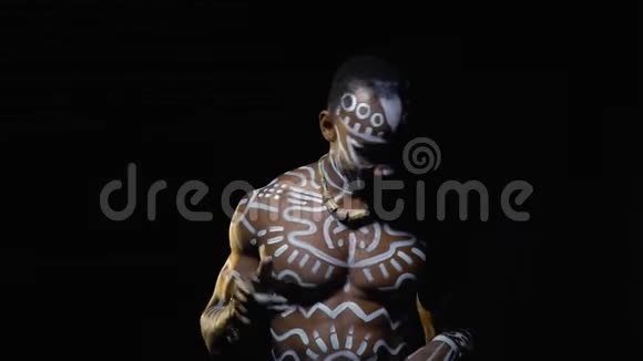 一个肌肉发达的白人黑人男子在黑暗中用手指拍打节奏视频的预览图