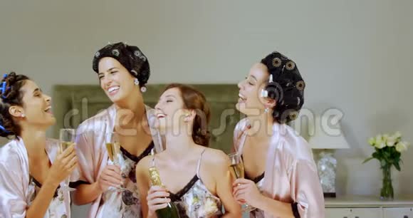 四个身穿睡衣的快乐伴娘喝一杯香槟视频的预览图
